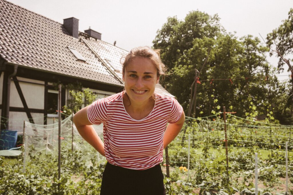 Frau in gestreiften Shirt vor einem Gemüsebeet