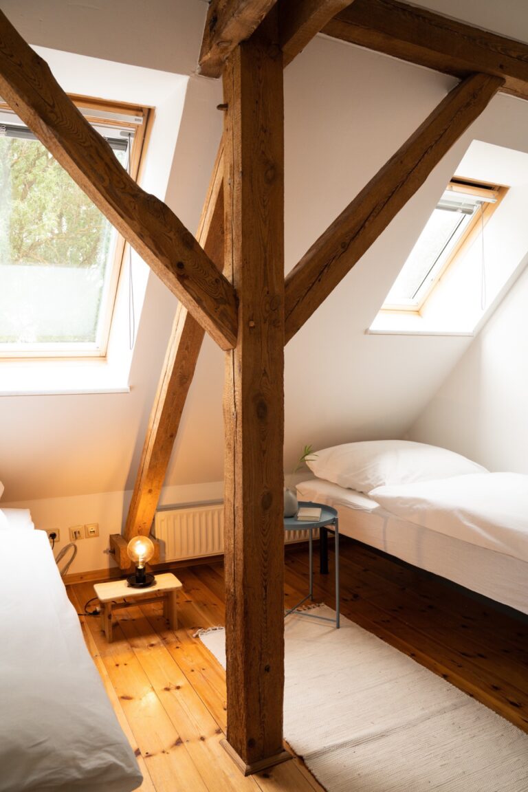 Zweibettzimmer Osten Zimmer mit Holzbalken und zwei weißbezogenen Betten