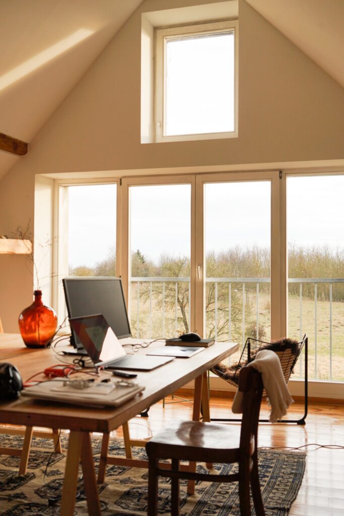 Yogaraum als Home-Office mit tollem Ausblick Schreibtische mit Computern vor großer Fensterfront